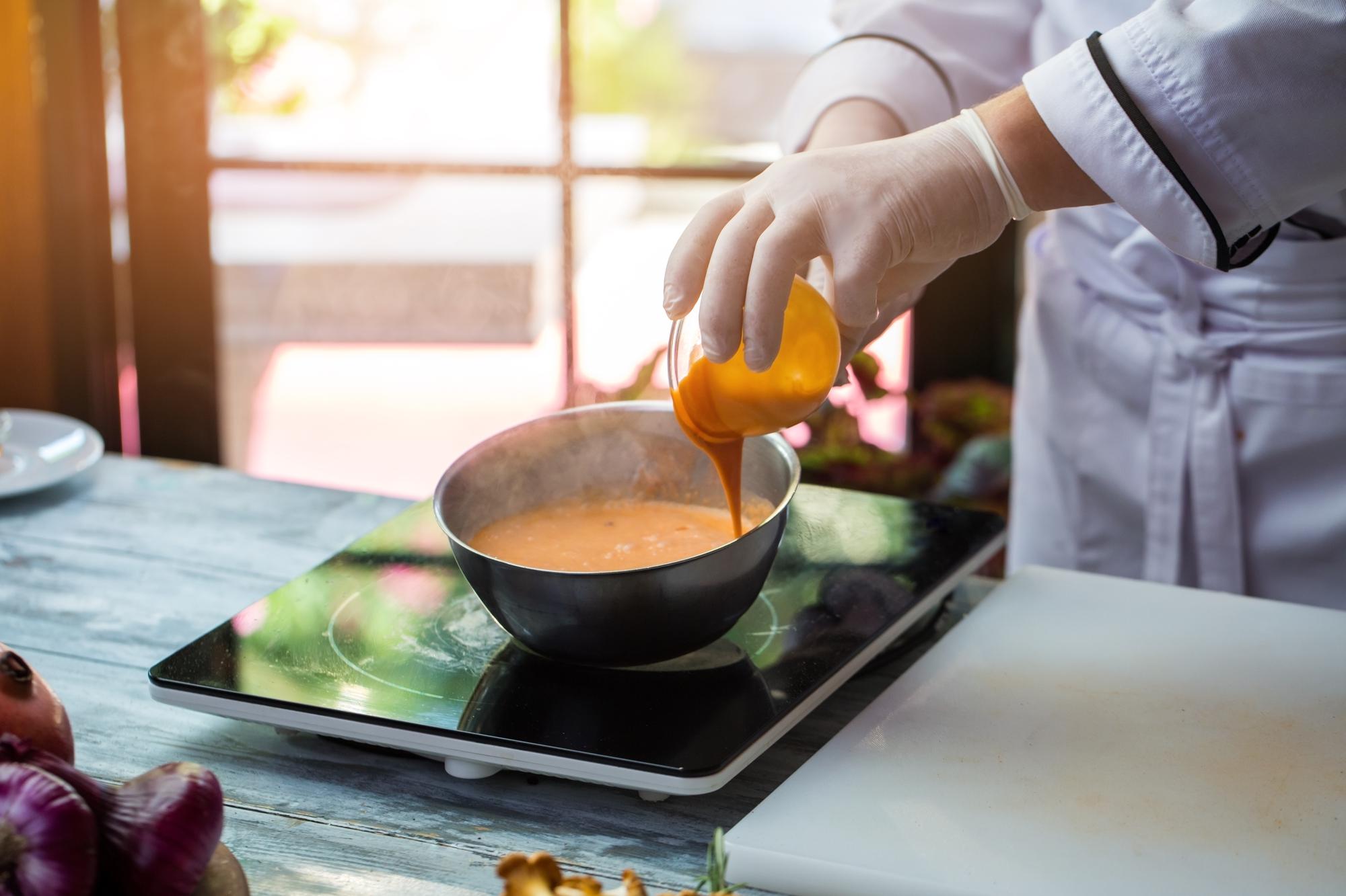 Hands finishing a sauce